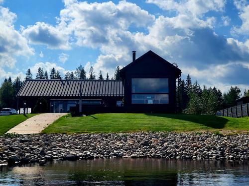 カヤーニにあるHuvilarannallaの水の横の丘の上の家