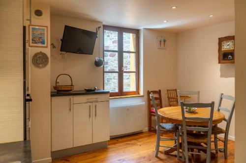 eine Küche und ein Esszimmer mit einem Tisch und einem Fenster in der Unterkunft La Maisonnette Etape de Saint-Côme d'Olt in Saint-Côme-dʼOlt