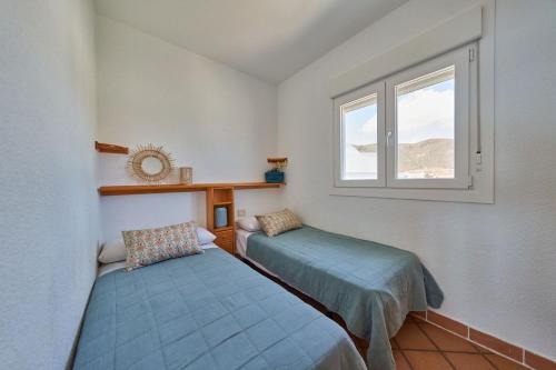 ein Schlafzimmer mit zwei Betten und einem Fenster in der Unterkunft Mirador de la Isleta in La Isleta del Moro