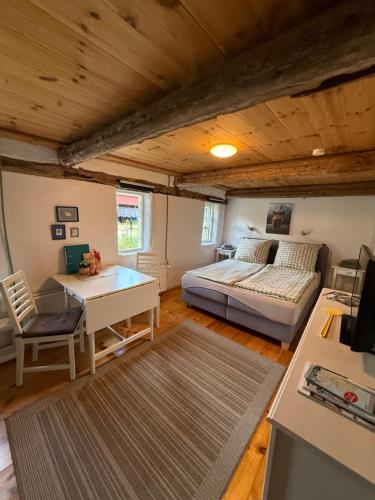 ein Schlafzimmer mit einem Bett, einem Schreibtisch und einem Tisch in der Unterkunft Ferienhof Faebrogaard in Skærbæk