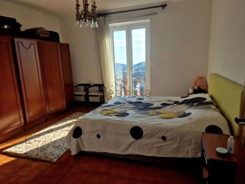 a bedroom with a bed with a large window at Casa Mare & Monti in Caprauna
