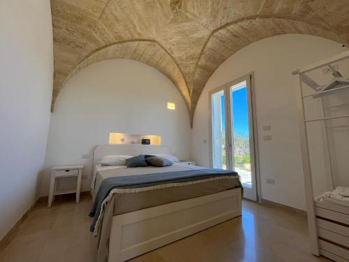 a bedroom with a bed in a room with arch ceilings at Villa Chiara by salentoltremare in Corsano