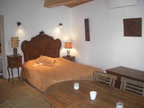 a bedroom with a large bed and a table at Maisonnette du berger de Croccano in Sartène