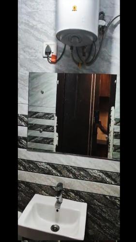 a bathroom with a sink and a mirror at Peaceful Stay at Microtek Greenburg EWS Located at Sec-86 Gurgaon Near NH8 IMT Manesar in Gurgaon