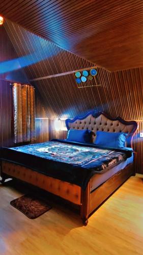 une chambre avec un lit avec un plafond en bois dans l'établissement Itzme Wings Resort, à Ooty