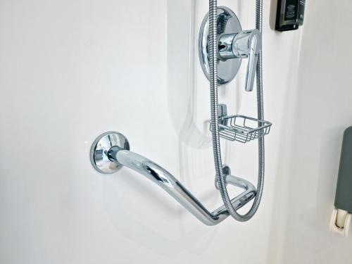 ein Duschkopf, der an einer Badezimmertür hängt in der Unterkunft ibis Caen Porte De Bretagne in Bretteville-sur-Odon