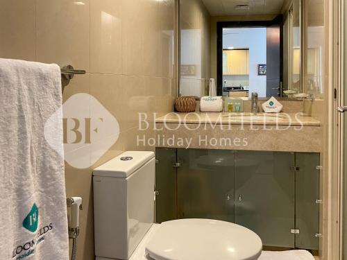 a bathroom with a white toilet and a sink at Bloomfields Spacious 1br In Sun Tower in Mushayrib