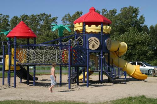 a man standing in front of a playground at Vakantiepark Callassande - CS 63 in Groote Keeten