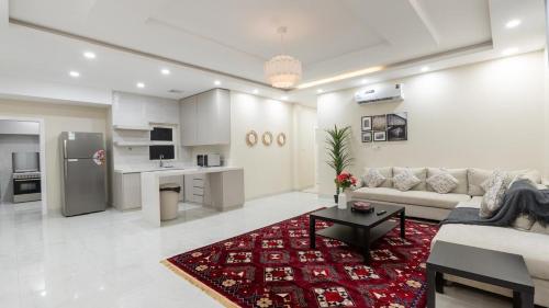 a living room with a couch and a table and a kitchen at Cozy Escape in Dammam