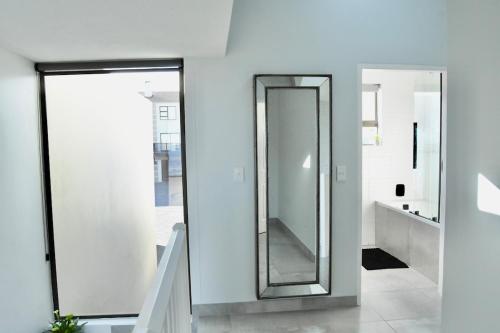 ein Badezimmer mit einem Spiegel an der Wand in der Unterkunft KB's Beach House in Langstrand