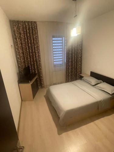 Un dormitorio con una cama blanca y una ventana. en Studio Central Ro1, en Râmnicu Vâlcea