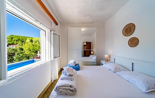 une chambre avec deux lits et une grande fenêtre dans l'établissement Waterfront House Arnet by Villas Guide, à Potirna