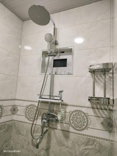 a shower in a bathroom with a sink and a mirror at "Sofia" Guest House-Hostel in Samarkand