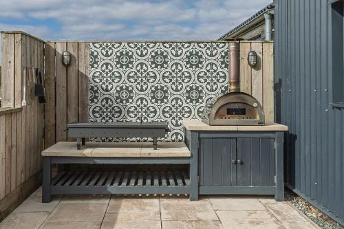a patio with a bench and a pizza oven at Butterfly in Boston