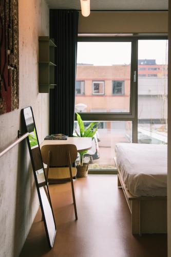a room with a bed and a table and a window at Hotel Jansen Amsterdam Bajeskwartier in Amsterdam