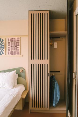 a door to a bedroom with a bed and a closet at Hotel Jansen Amsterdam Bajeskwartier in Amsterdam