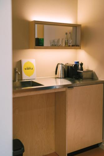 a kitchen with a sink and a counter top at Hotel Jansen Amsterdam Bajeskwartier in Amsterdam