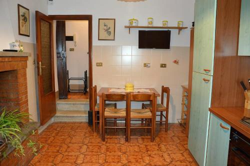 a kitchen with a table with chairs and a television at Le Scalette in Acquapendente