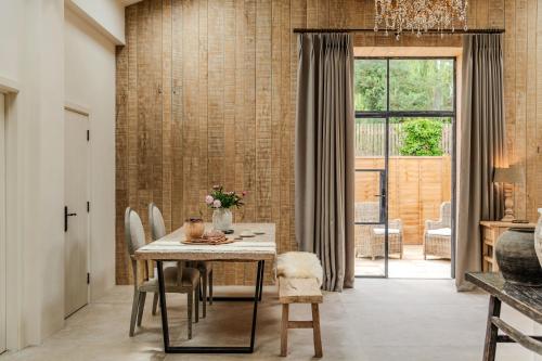 a dining room with a table and chairs and a window at Luxury Cotswold Retreats in Moreton in Marsh
