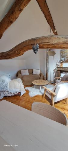 a living room with a couch and a table at Le Grenier des Moineaux Chezchristineetfabrice in Odeillo-Via