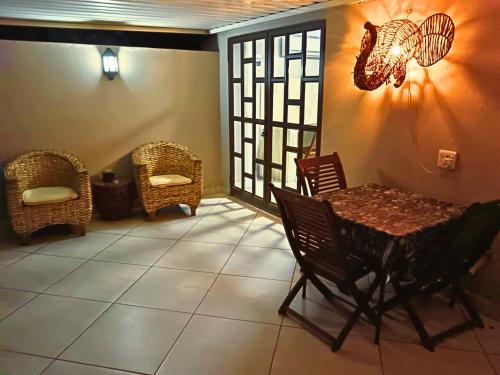 a room with a table and chairs and a window at The Wilds Guest House in Hluhluwe