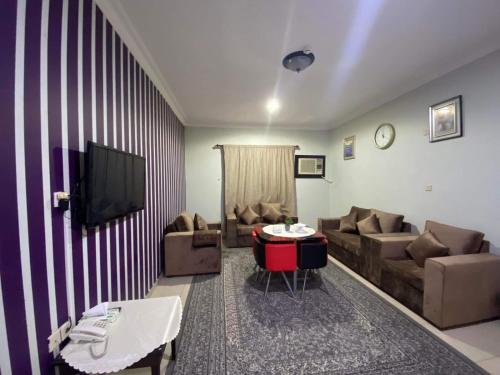 a living room with a couch and a tv at شركة العييري للشقق المخدومة - إقتصادي Al-Eairy Serviced Apartments Company in Al Hofuf
