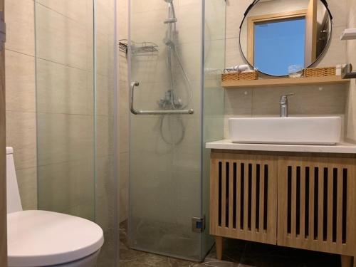 a bathroom with a shower and a sink and a mirror at FLC SEA TOWER YẾN MINH Apartment in Quy Nhon