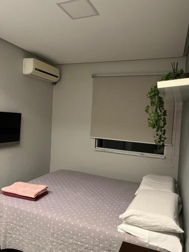 ein Schlafzimmer mit einem Bett und einem Fenster in der Unterkunft Casa aconchegante em Aracaju na Aruana in Aracaju