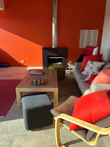 a living room with orange walls and a fireplace at Perisher stand alone chalet - available all year in Perisher Valley