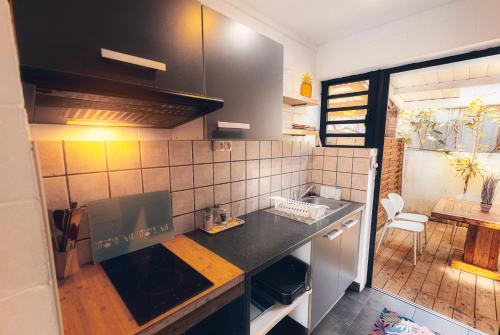 a kitchen with a sink and a counter top at Kaz Nomia - à 50m de la plage Roches Noires in Saint-Gilles les Bains