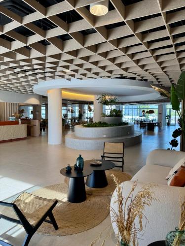 a lobby with tables and chairs in a building at Canvas Sevilla Lago in Seville