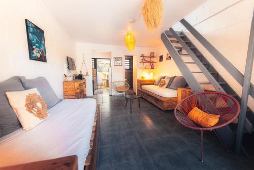 a living room with a bed and a staircase at Kaz Nomia - à 50m de la plage Roches Noires in Saint-Gilles les Bains