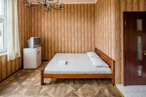 a small bedroom with a bed and a tv at Studio on Kopernyka street in Lviv