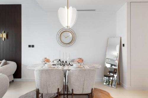 a dining room with a table with chairs and a mirror at Novity Luxury Vida Marina 2BR Sea View 40th Floor in Dubai