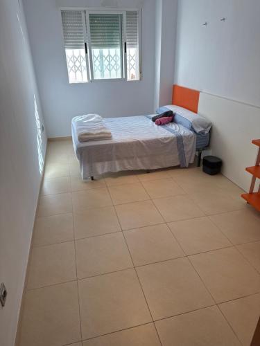 a bedroom with a bed and a tiled floor at Y&To in Grao de Castellón