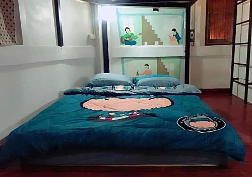 a bedroom with a bed with a joker comforter at Chiangmai by DD&B hostel in Chiang Mai