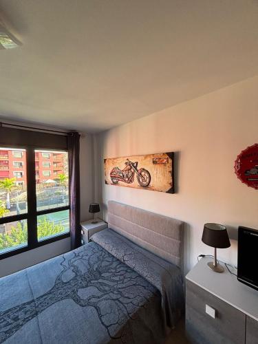 a bedroom with a bed and a picture of a motorcycle on the wall at El Mocan Apartment Palm Mar in Palm-mar