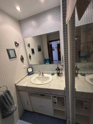 a bathroom with a sink and a mirror at El Mocan Apartment Palm Mar in Palm-mar