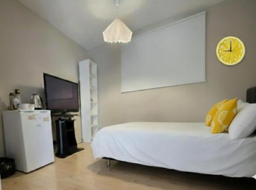 a bedroom with a bed and a clock on the wall at Casa de Limón - סוויטות בוטיק וספא יוקרתיות בגליל העליון in Sede Eli‘ezer