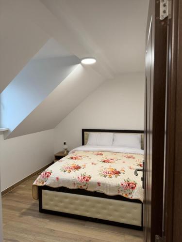 a bedroom with a bed with a floral comforter at La Tranquillité Citadine in Schiltigheim