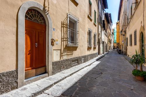 an alley with a red door on a building at Passera Royal Suite in Florence