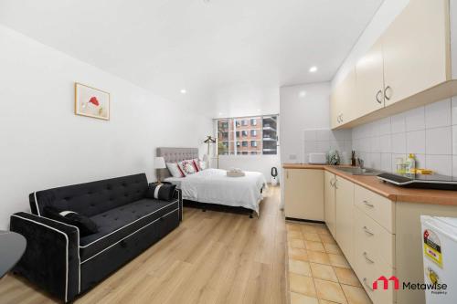 a kitchen and a living room with a couch and a bed at MetaWise BnB Bright 1Bed Studio Near Kings Cross in Sydney