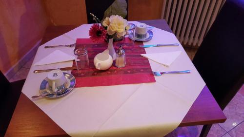 a white table with a vase of flowers on it at Sunny´s Hotel & Residence in Mainz
