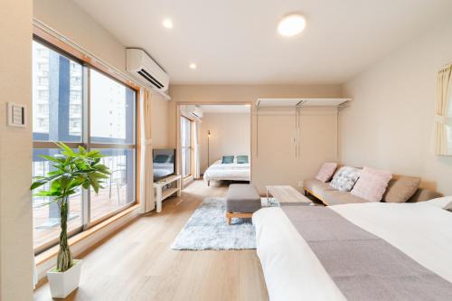 een slaapkamer met een bed en een woonkamer met een bank bij Terrace Tokyo Otsuka in Tokyo