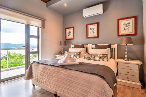 een slaapkamer met een groot bed en een raam bij Bush Baby View Lodge in Hartbeespoort