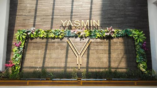 Un cartel en el lateral de un edificio con flores. en Yasmin Hotel Karawaci, en Tangerang
