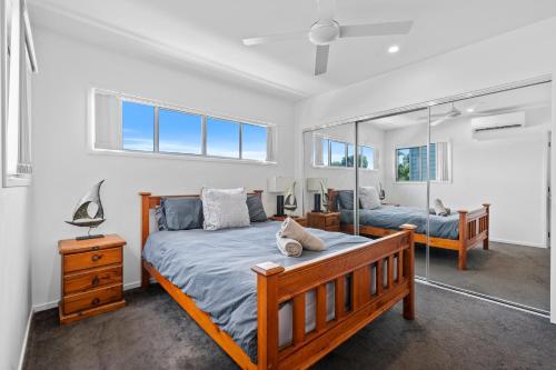 een slaapkamer met twee bedden en een spiegel bij Laid-Back Wurtulla Escape with Style & Charm in Kawana Waters
