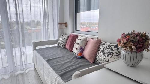 a bed with pillows on it in a room with a window at EtyekZen in Etyek