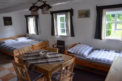 a bedroom with two beds and a table and chairs at Penzion U kozy in Chřibská