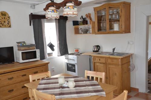 a kitchen with a table and a kitchen with a sink at Penzion U kozy in Chřibská
